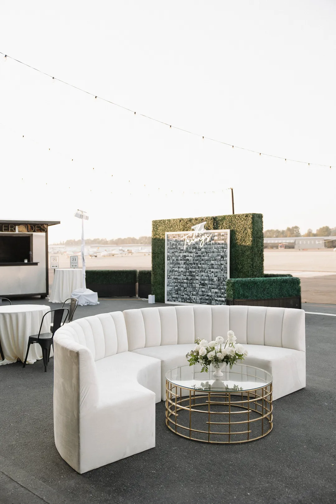 Curved white lounge seating around a gold-framed coffee table.