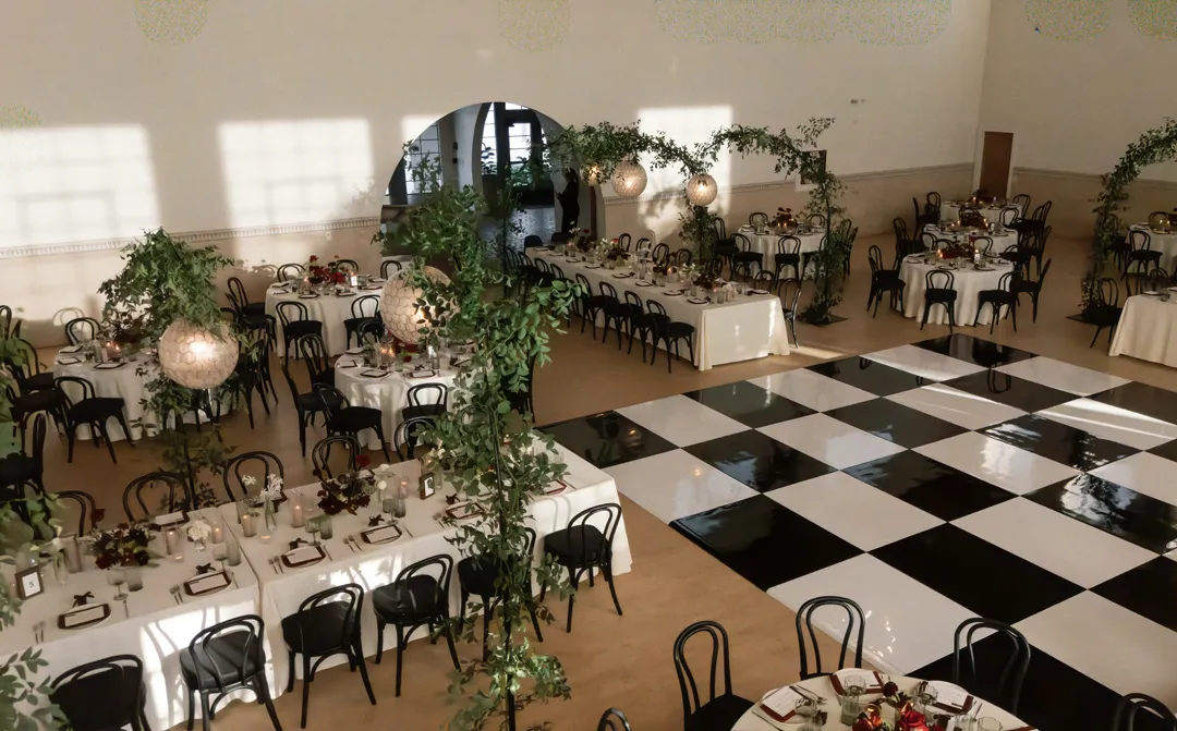 Reception tables surrounding a black-and-white checkered dance floor.