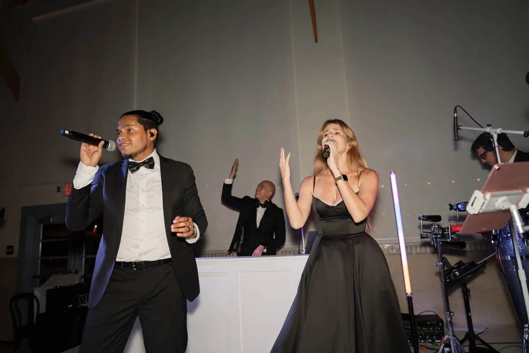 Two singers performing with the wedding reception band.