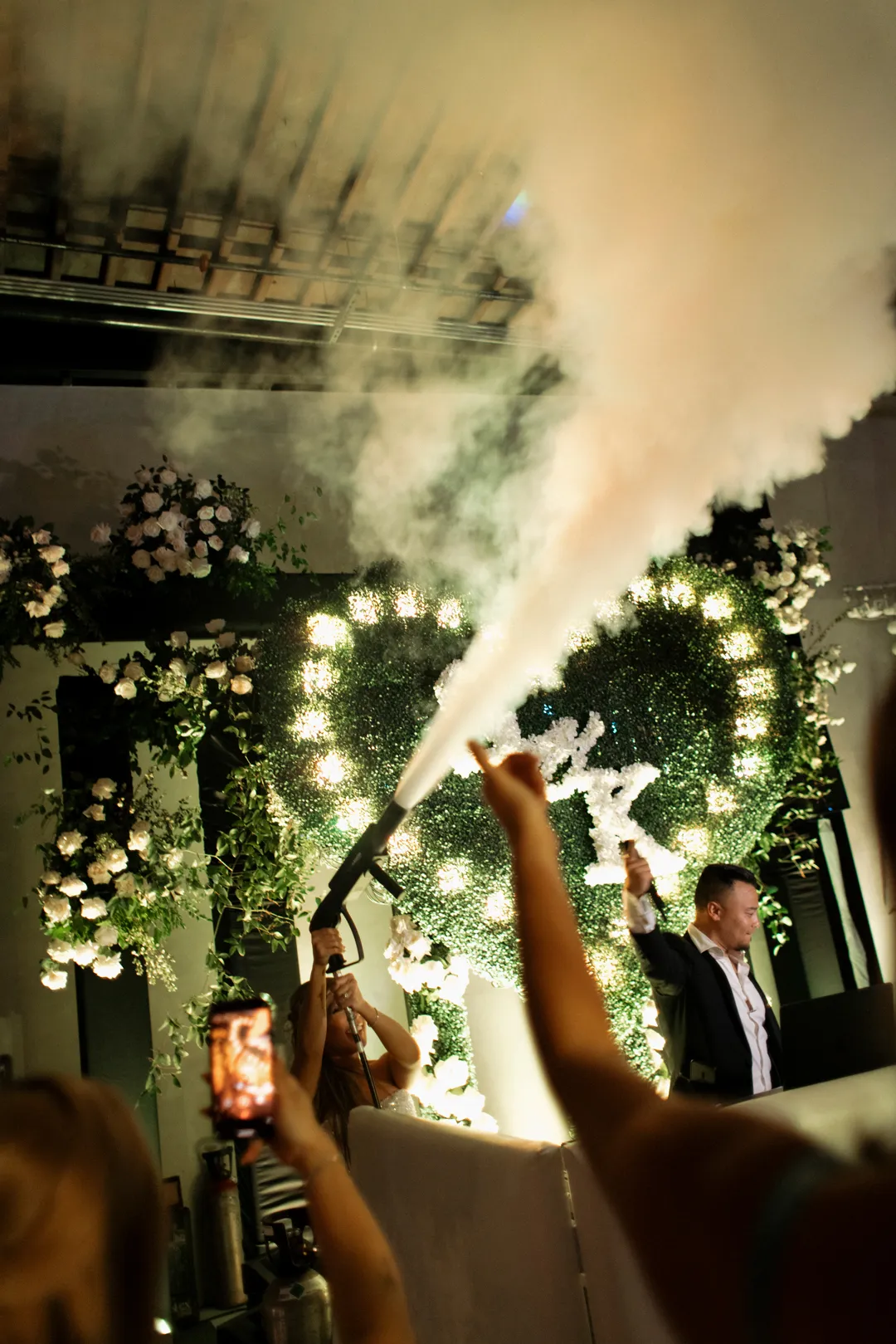 Reception celebration with a handheld fog effect above the dance floor.