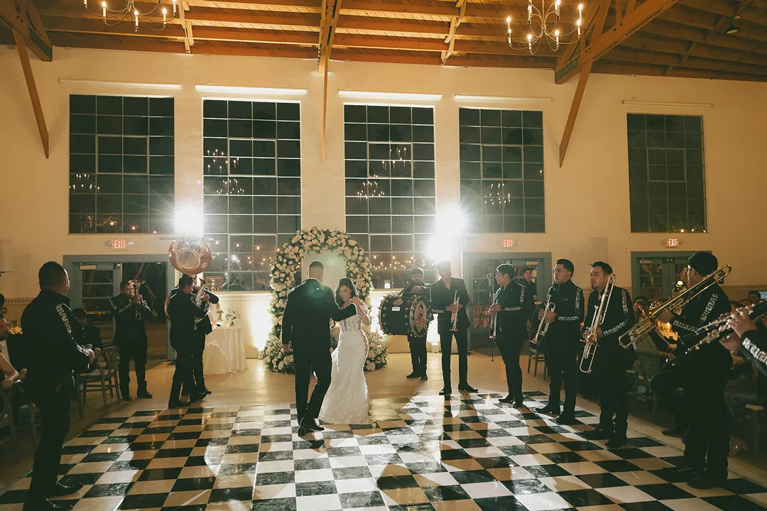 Wedding couple dancing surrounded by live musicians.