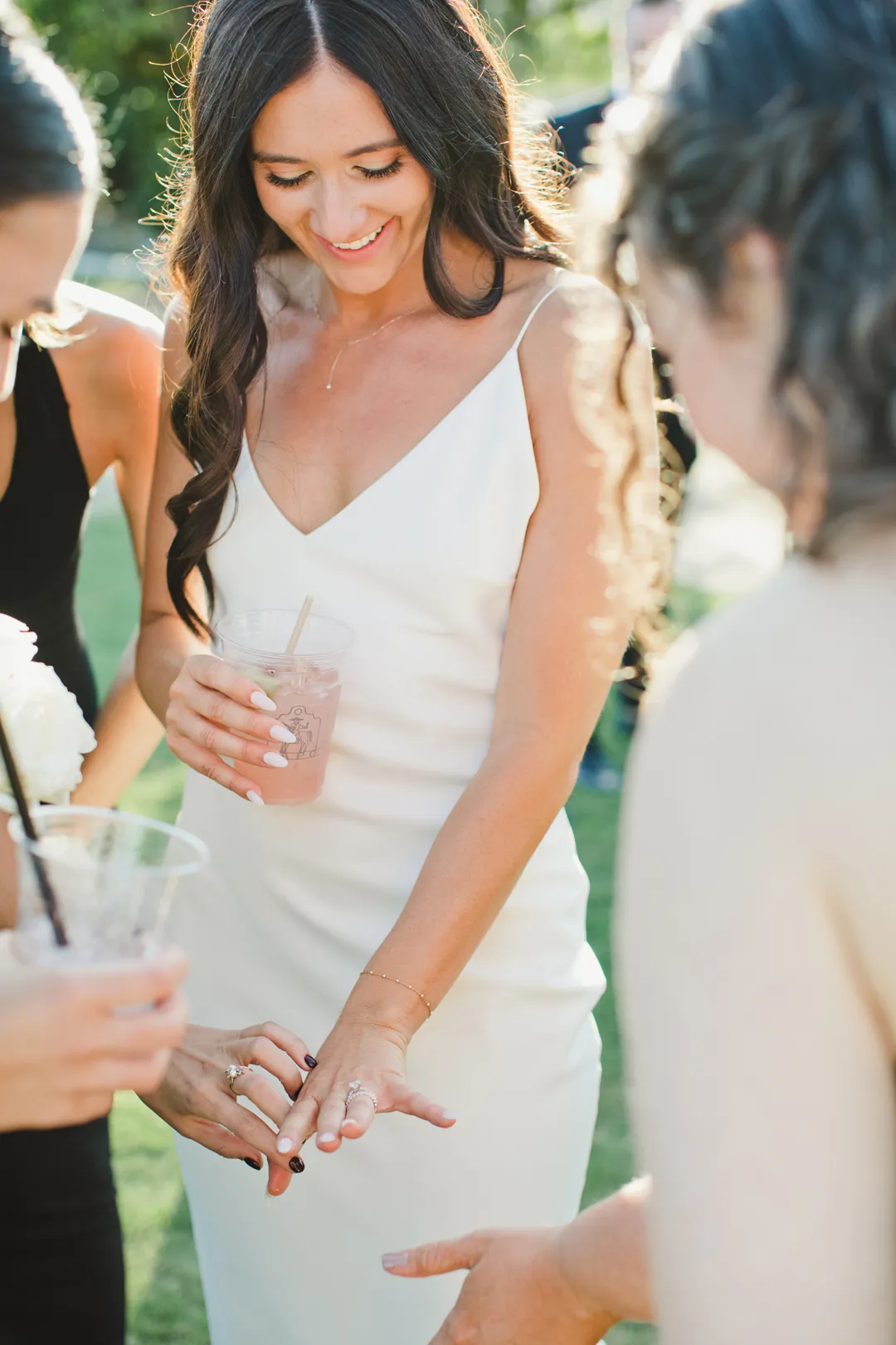 Bride showing her wedding ring to guests during cocktail hour.