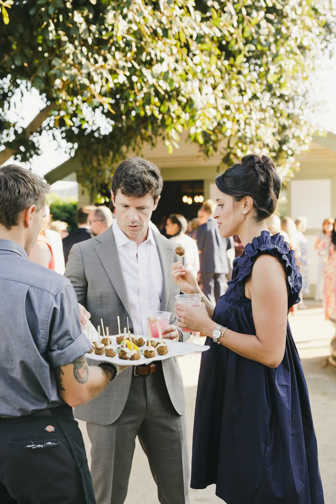 Wedding guests enjoying passed appetizers outdoors.