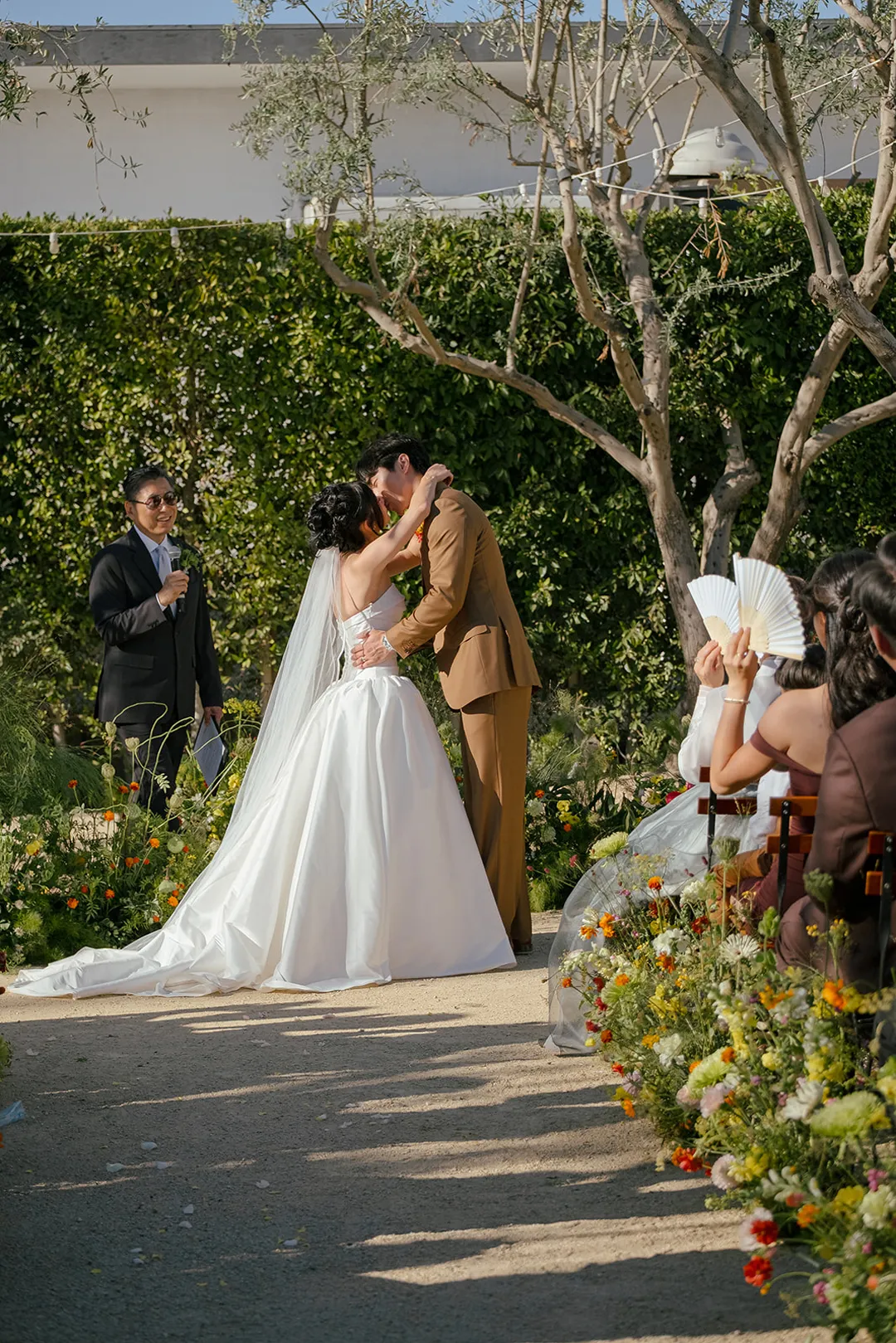 Wedding couple kissing at the end of the outdoor ceremony.