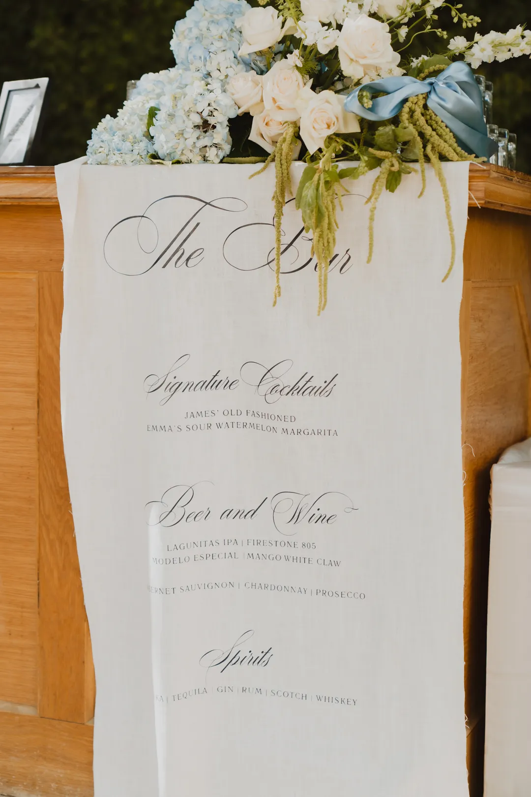 Fabric bar menu beneath an arrangement of blue and white flowers.
