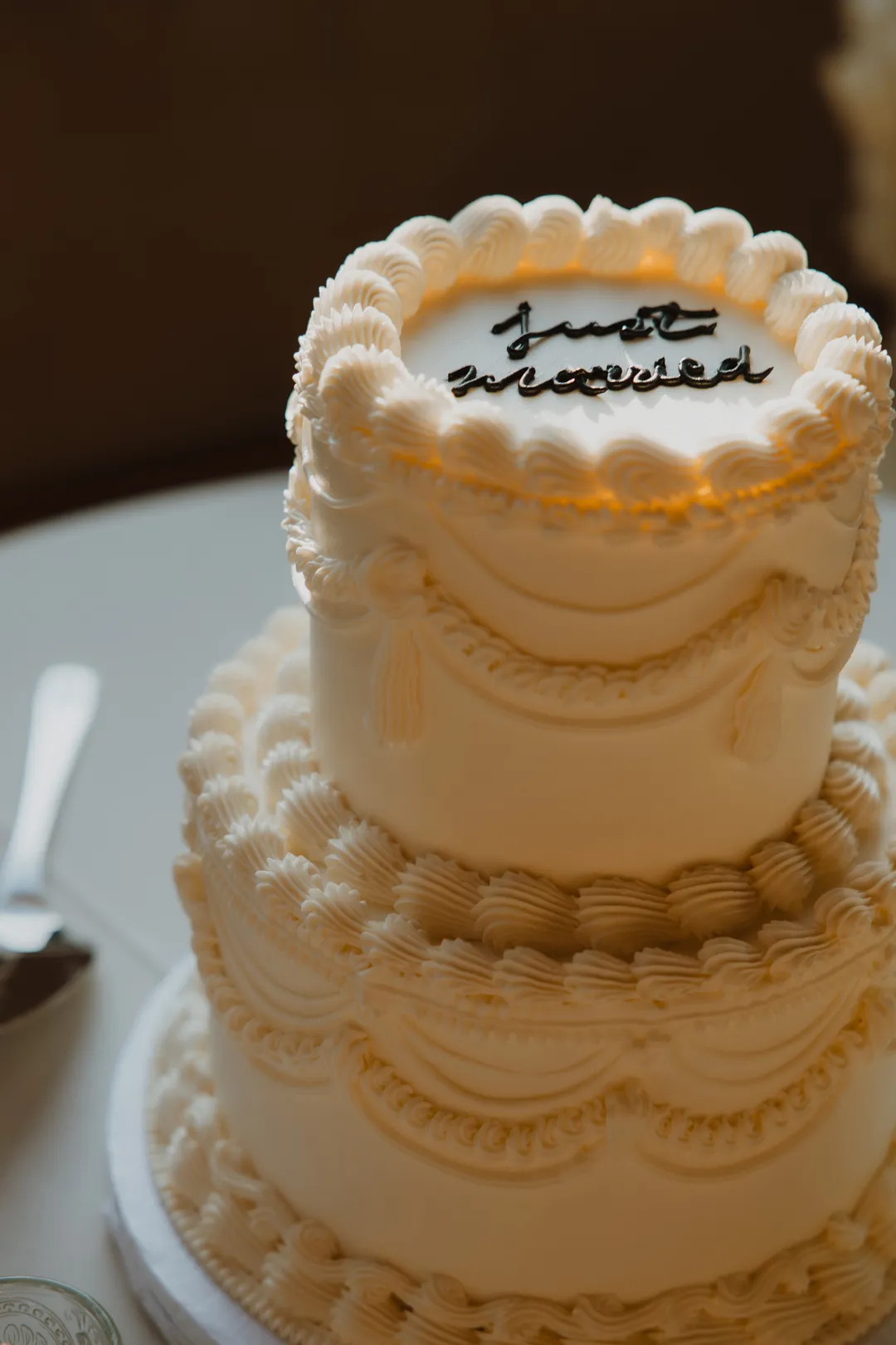 Close-up of piped wedding cake with Just Married lettering.