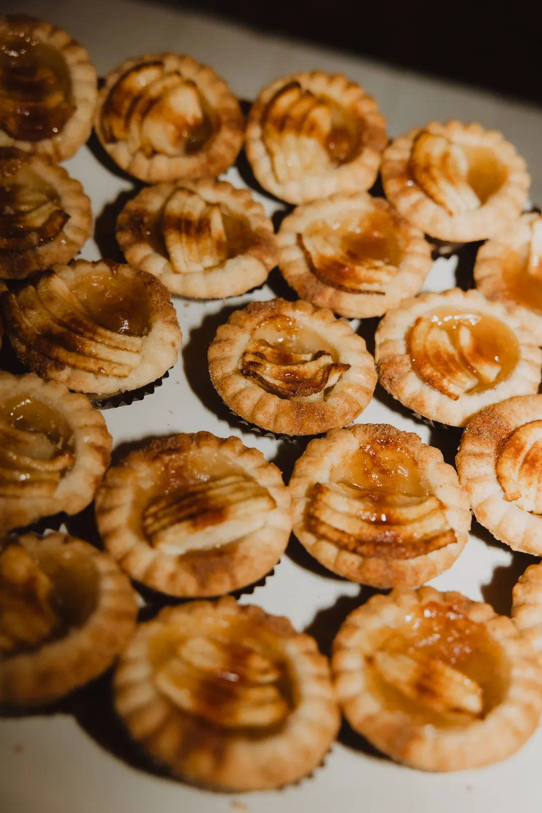 Miniature apple tarts with thinly sliced fruit.