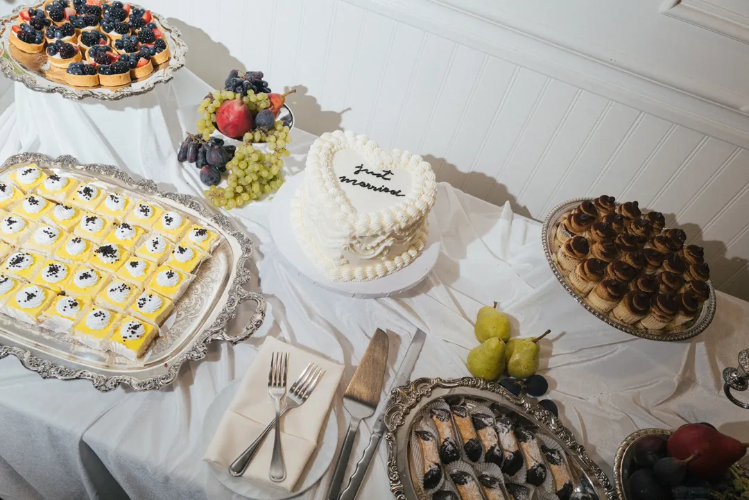 Overhead view of a wedding cake and assorted miniature desserts.