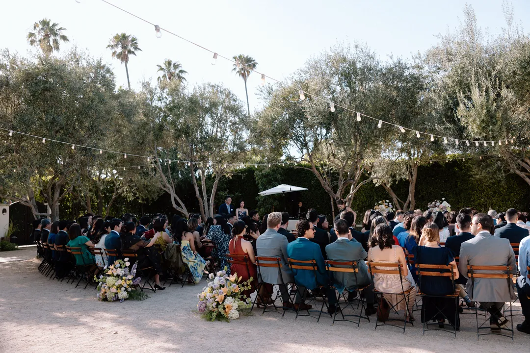 Guests seated for an outdoor wedding ceremony.