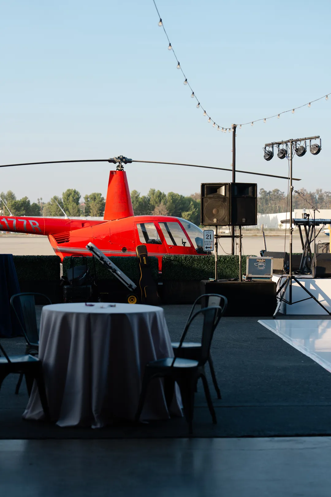 Red helicopter beside outdoor cocktail tables at Hangar 21 South.