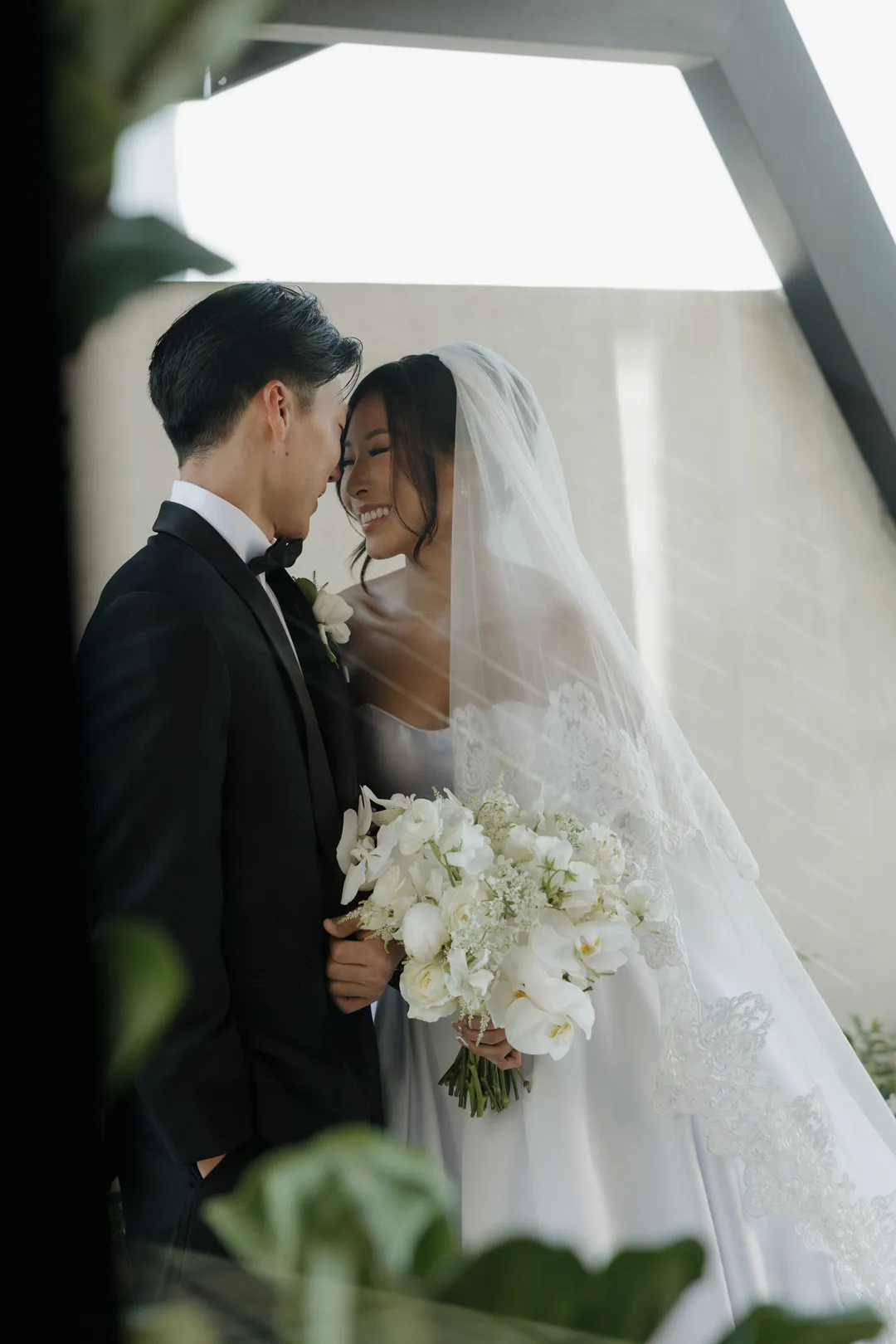 Close portrait of the wedding couple with a white floral bouquet.