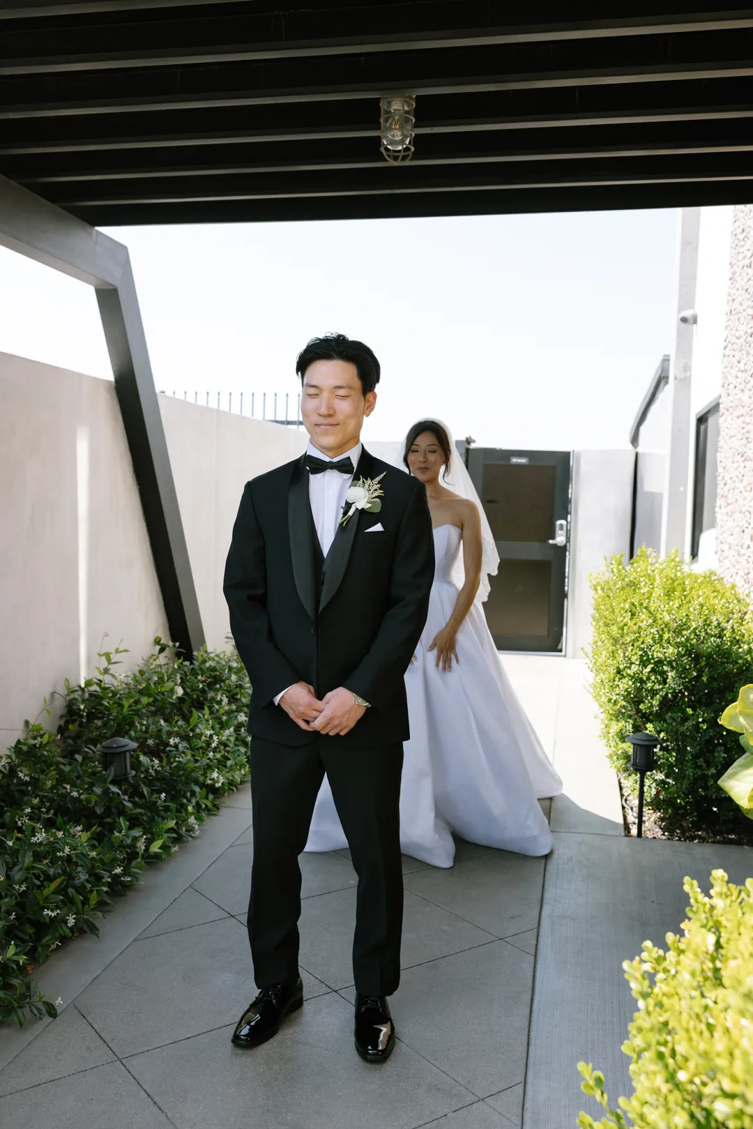 Bride approaching the groom for a first look outside Hangar 21 South.