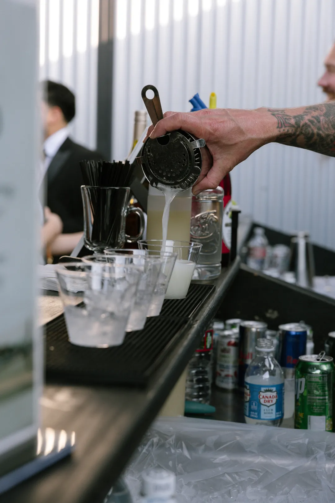 Bartender pouring cocktails at the Hangar 21 South reception.