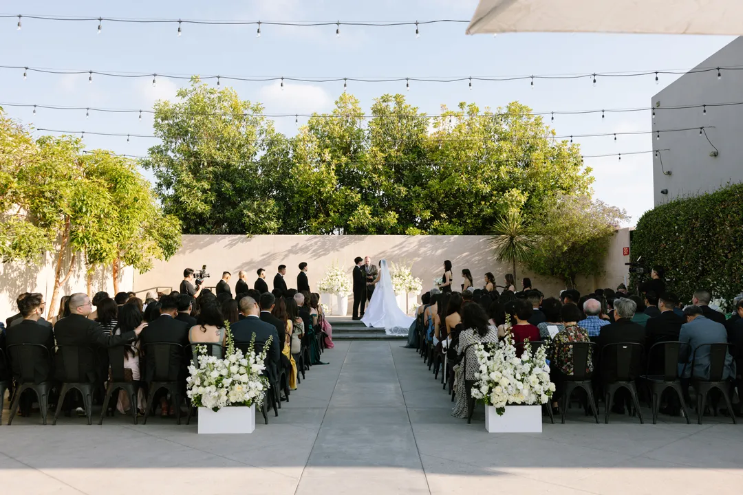 Guests seated for the outdoor wedding ceremony at Hangar 21 South.