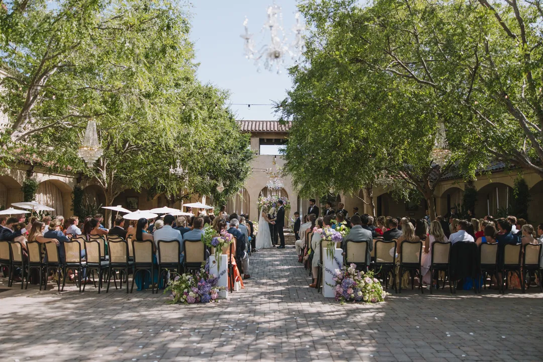 Guests seated for a wedding ceremony in the Serra Plaza courtyard.