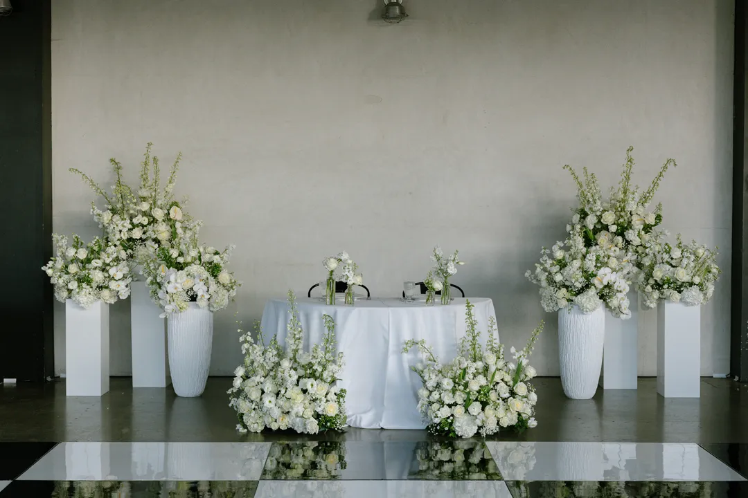 Sweetheart table surrounded by white flowers at Hangar 21 South.