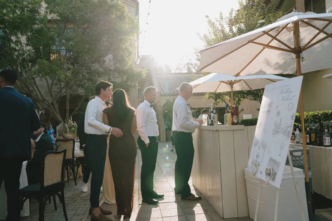 Guests gathered at the Serra Plaza outdoor bar beneath cream umbrellas.