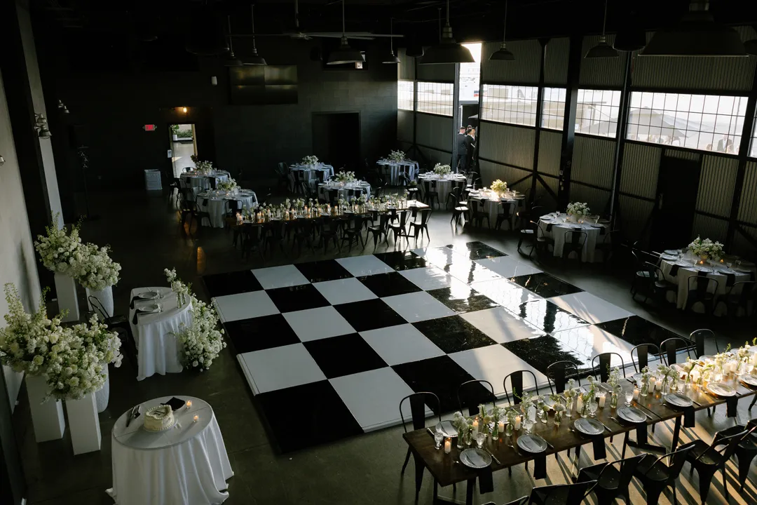 Elevated view of the checkered dance floor and wedding tables at Hangar 21 South.