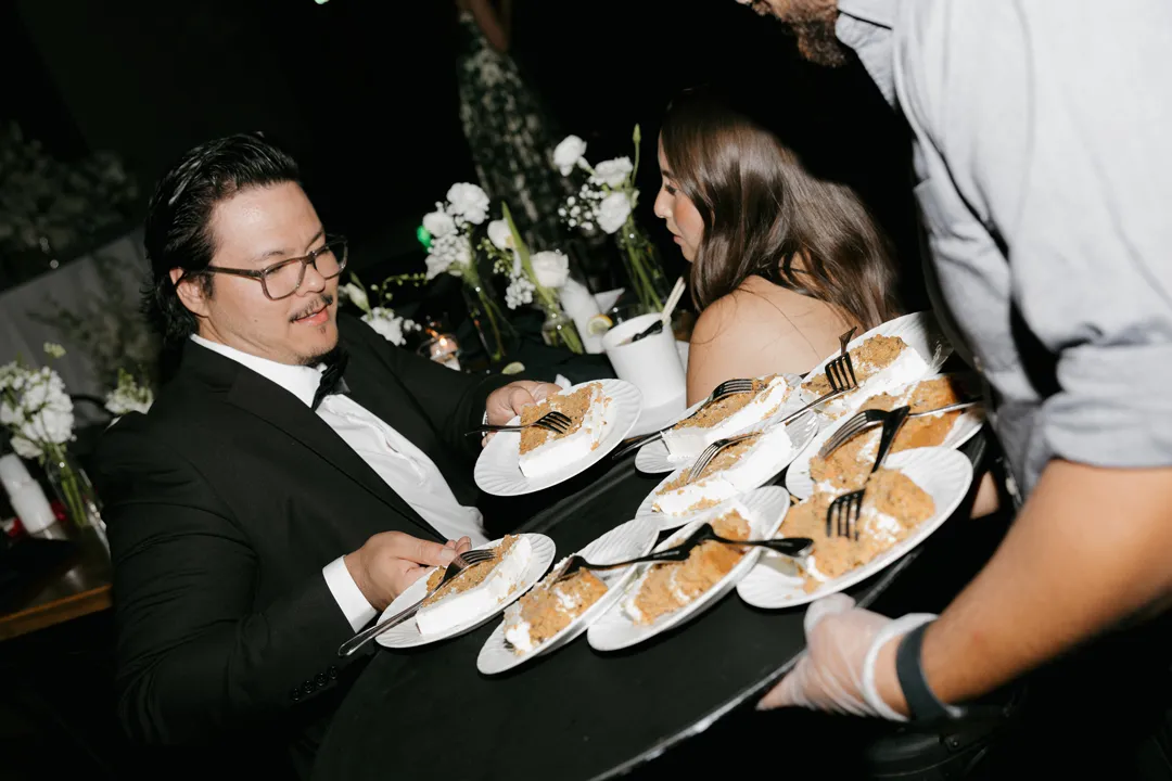 Server offering slices of Jay's Catering carrot cake to wedding guests.
