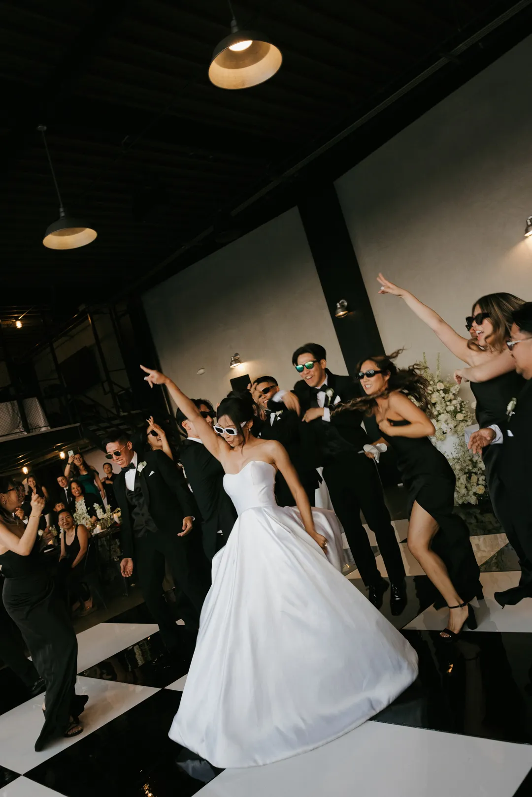 Wedding party celebrating on the checkered dance floor at Hangar 21 South.