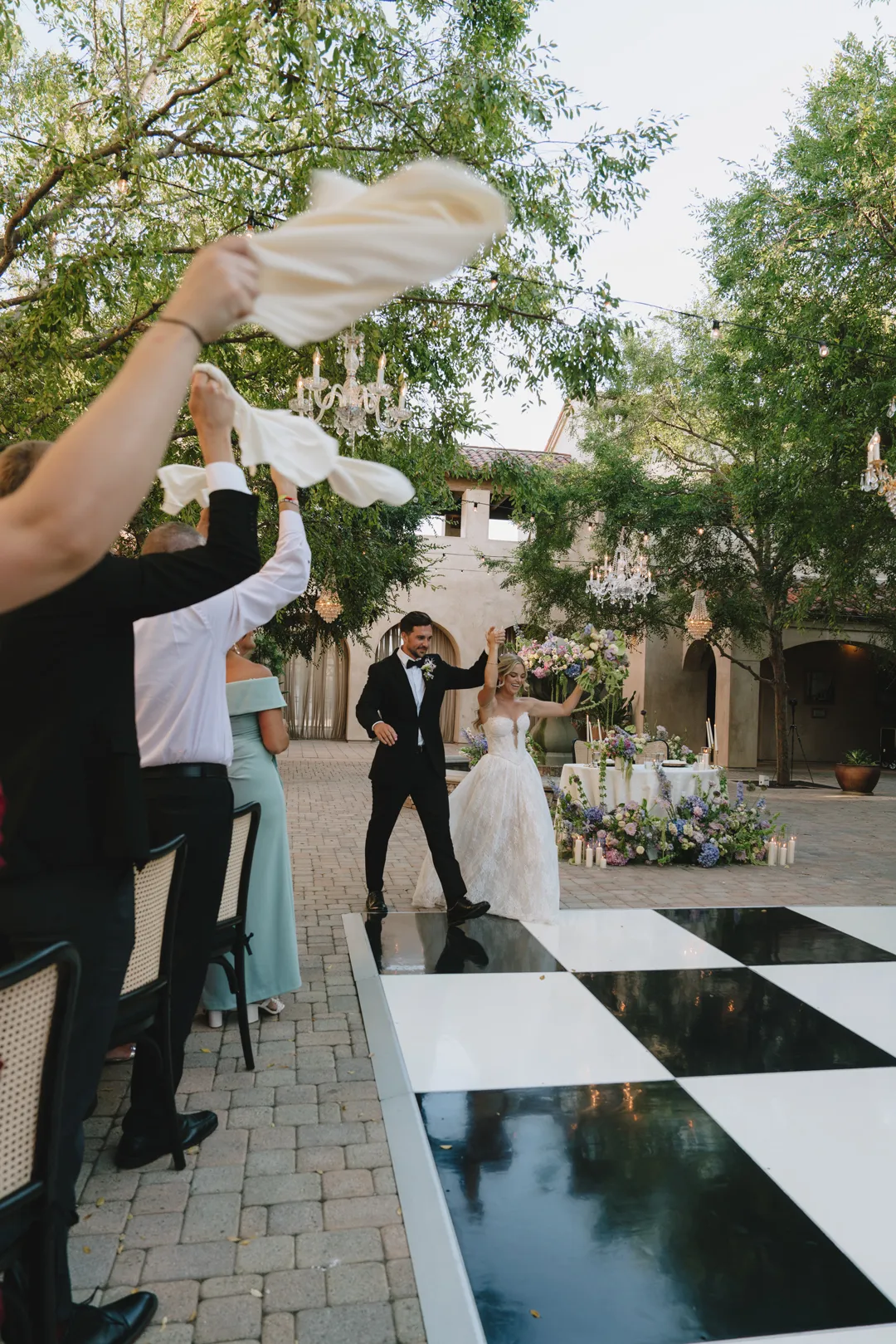 Guests waving napkins as the newlyweds enter the Serra Plaza reception.