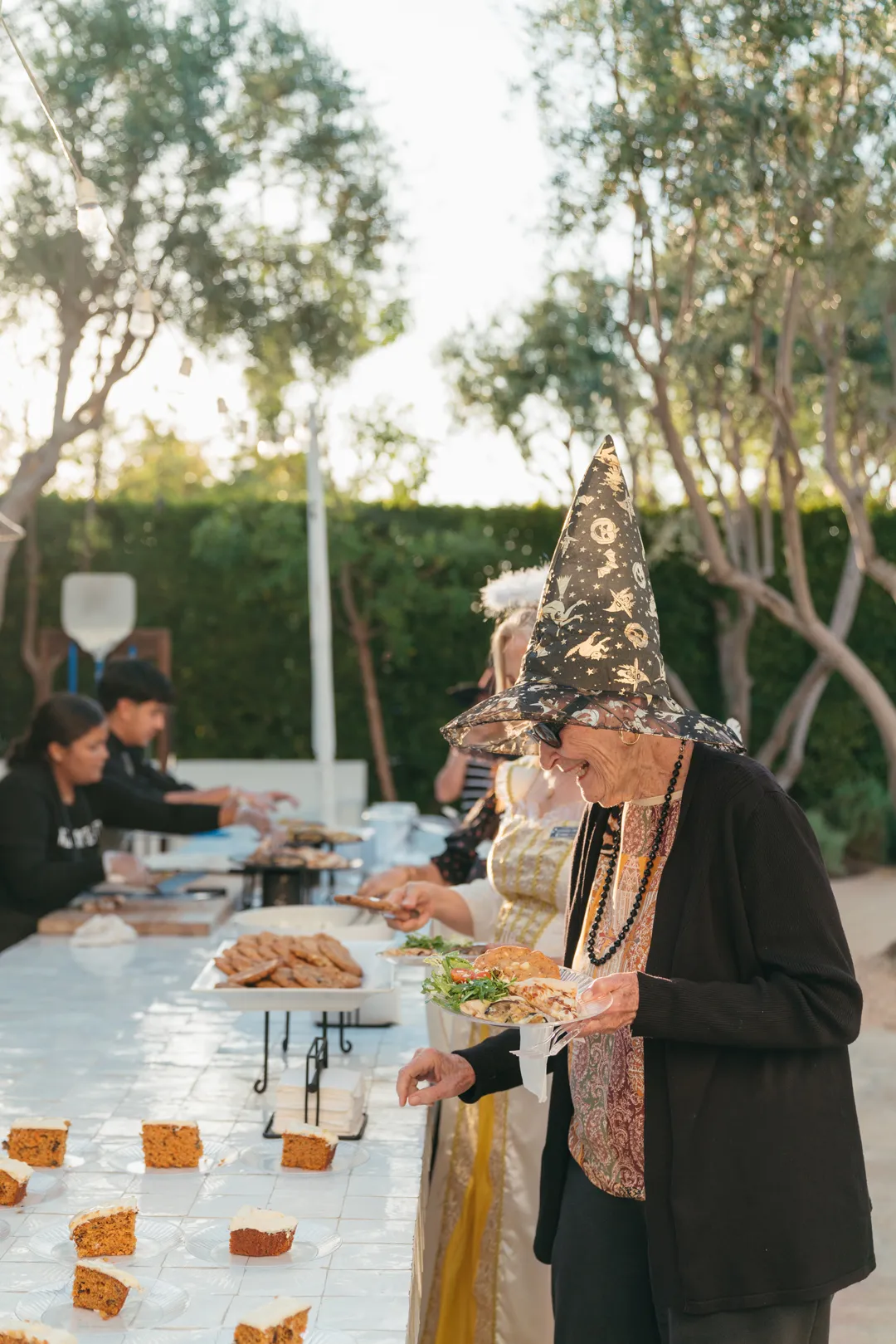 Guest selecting carrot cake at Grand Gimeno's Halloween-themed CHOC Guild Con.