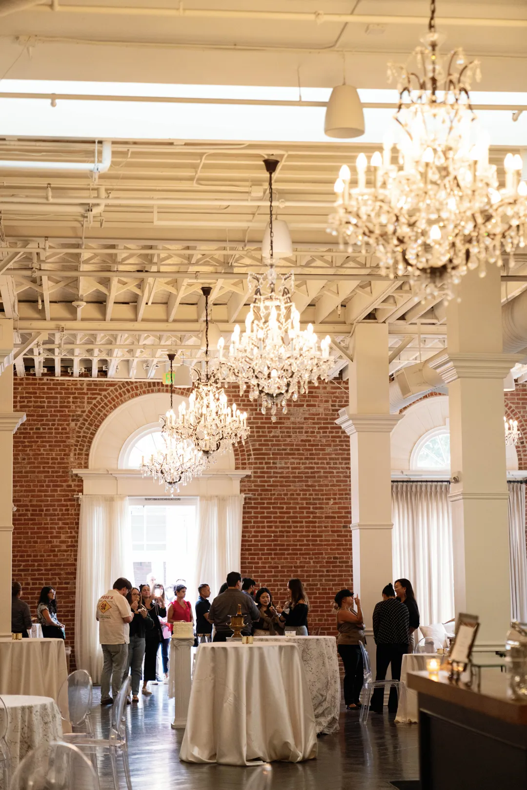 Taste of Jay's guests mingling beneath The Estate on Second ballroom chandeliers.