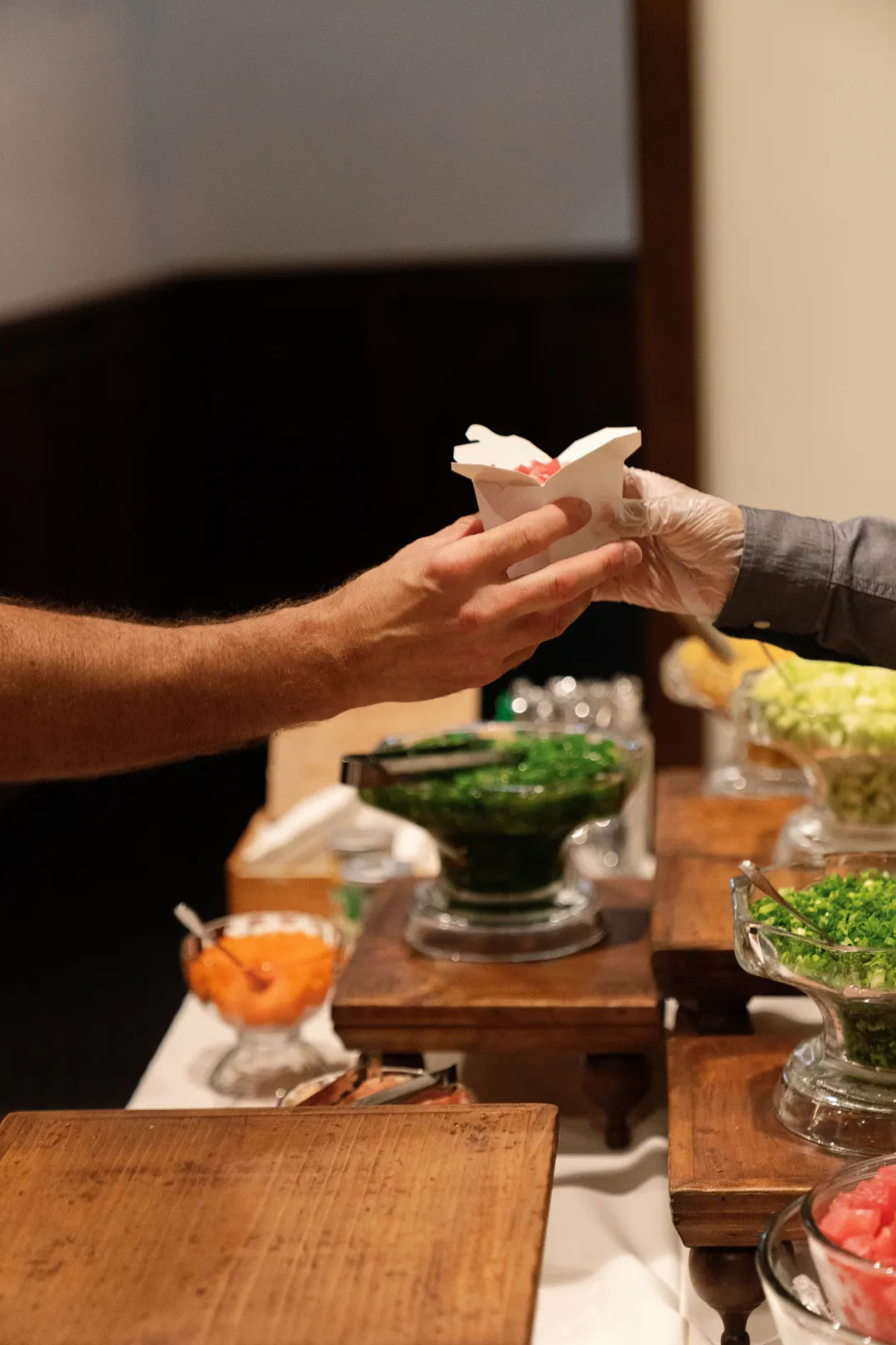 Server handing a Poke Station tasting carton to a guest at Taste of Jay's.