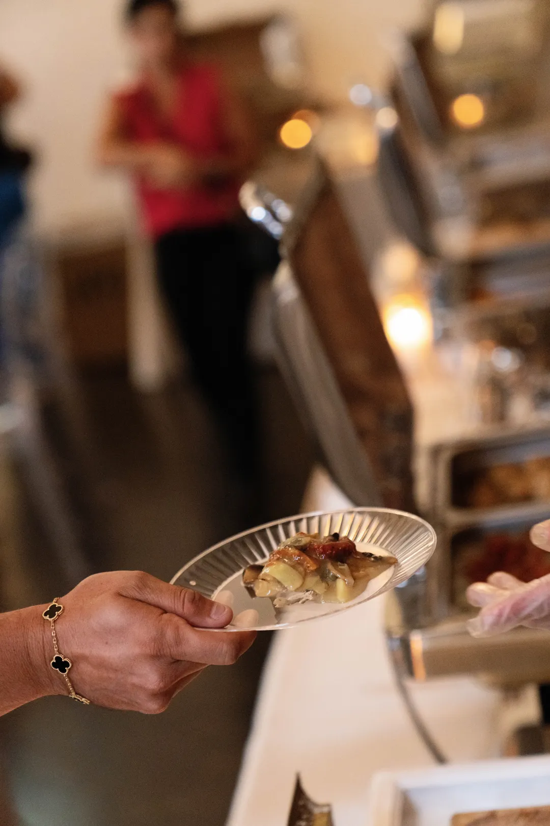 Guest holding a small tasting plate at the buffet.