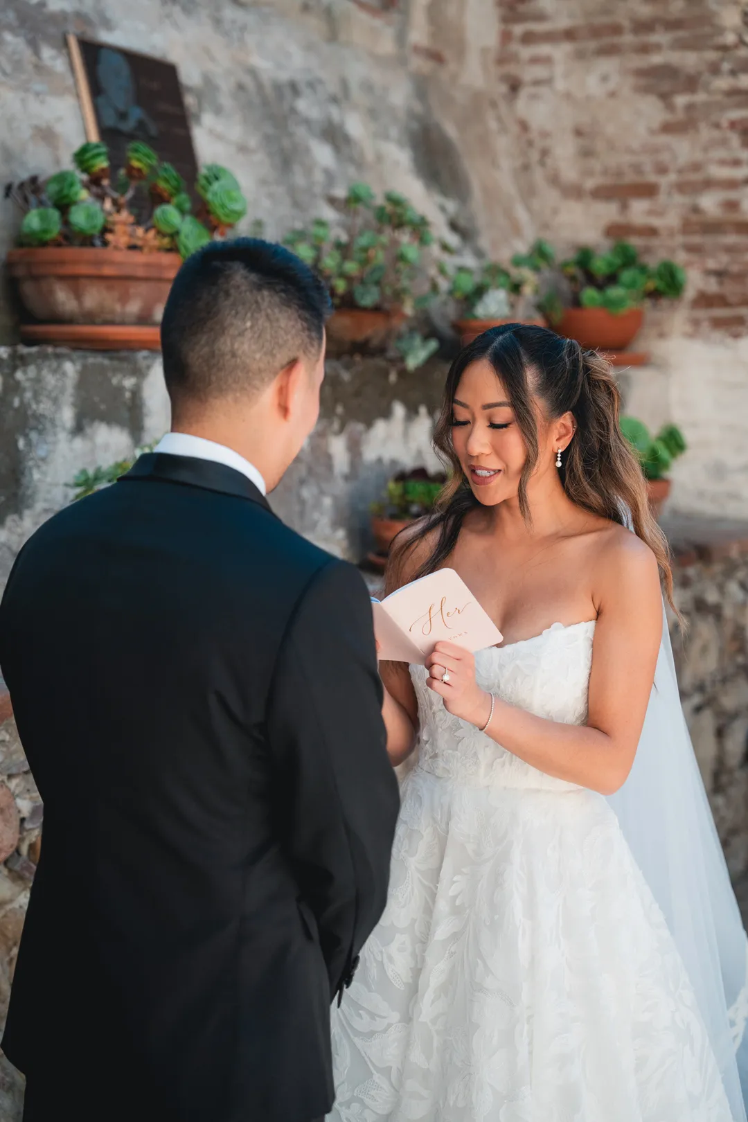 Bride reading private vows to the groom in Mission San Juan Capistrano's Sacred Garden.