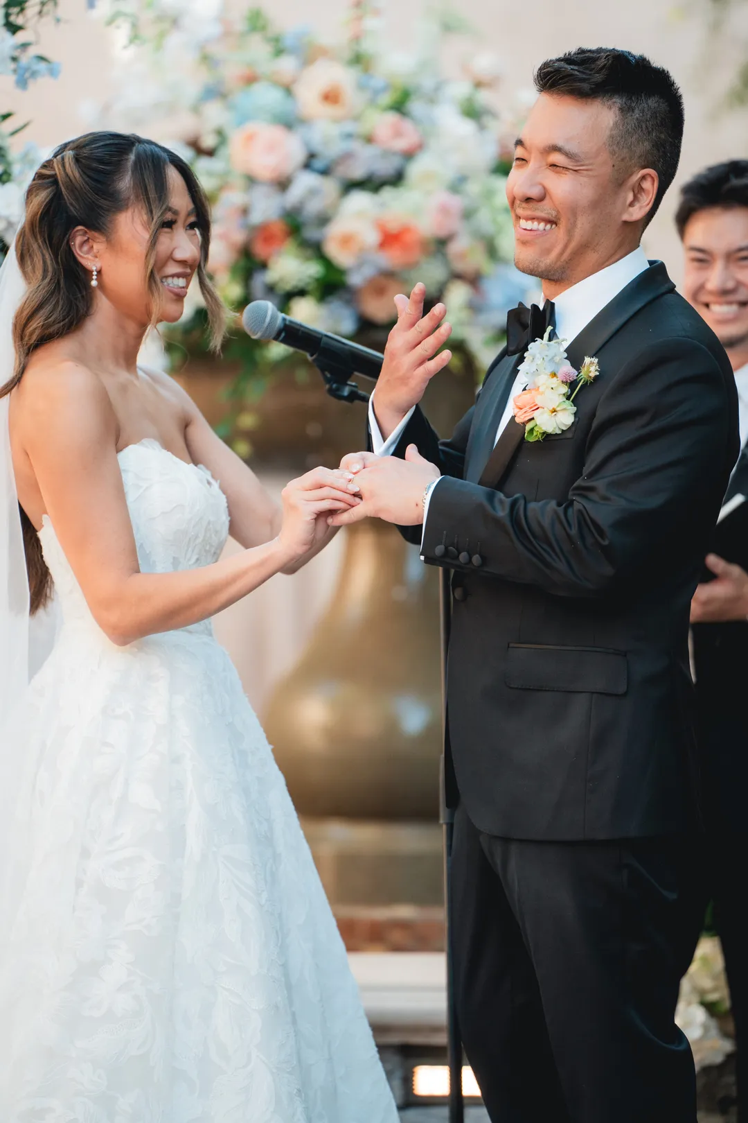 Newlyweds smiling during their ring exchange.
