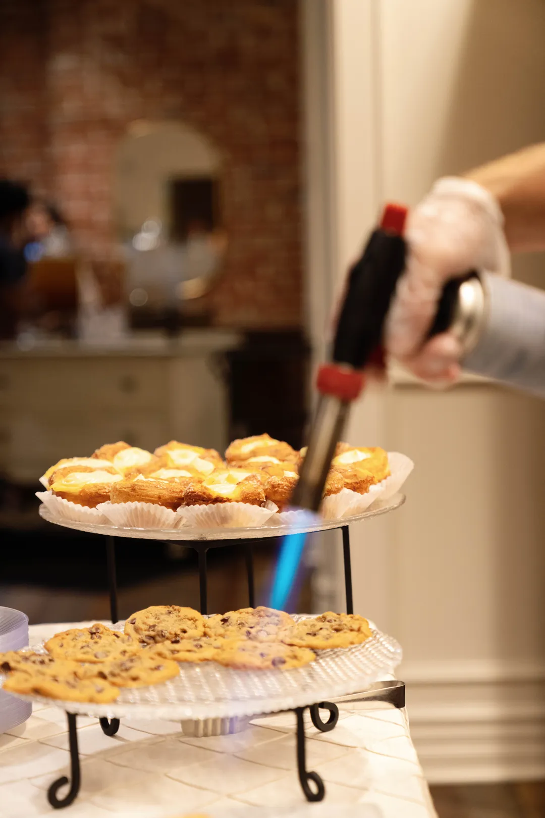Kitchen torch caramelizing Jay's Catering Kouign Amann pastries.