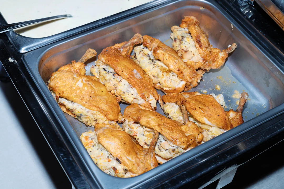 Roasted stuffed chicken portions in a buffet tray.