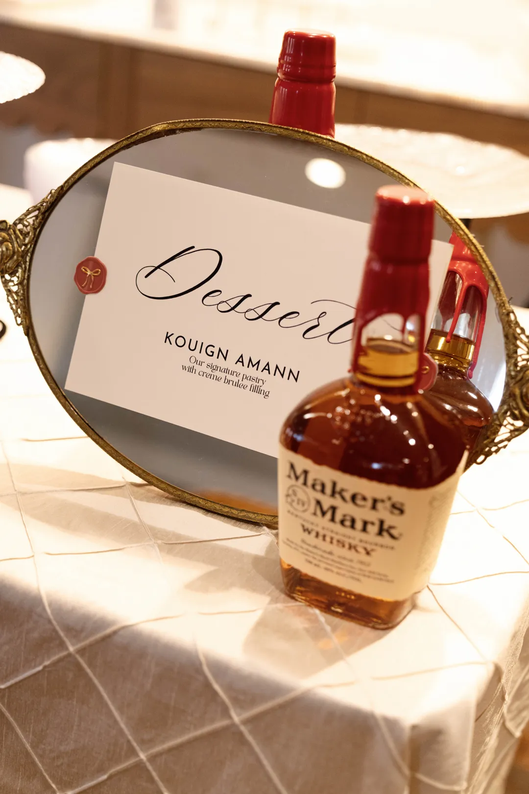 Kouign Amann dessert sign beside a bourbon bottle at Taste of Jay's.