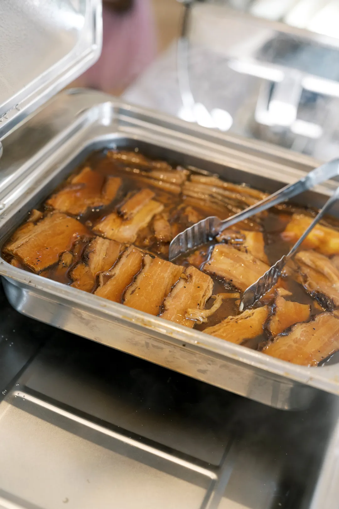 Braised pork belly in a serving tray at Jay's Catering's bao station.