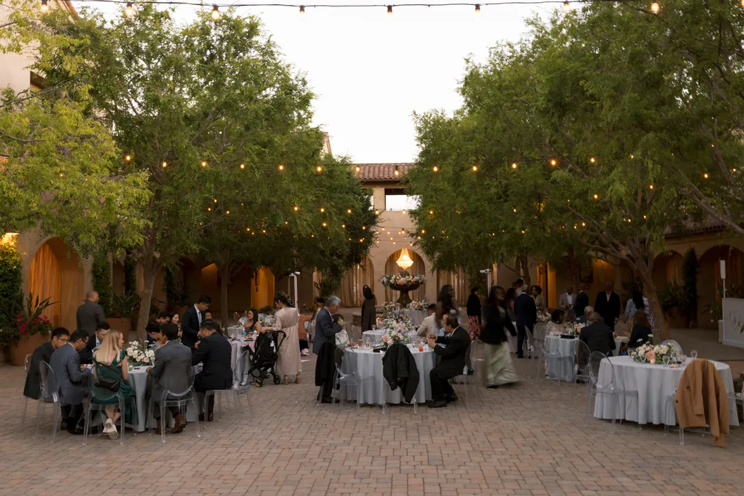 Guests dining beneath the Serra Plaza courtyard chandeliers and string lights.
