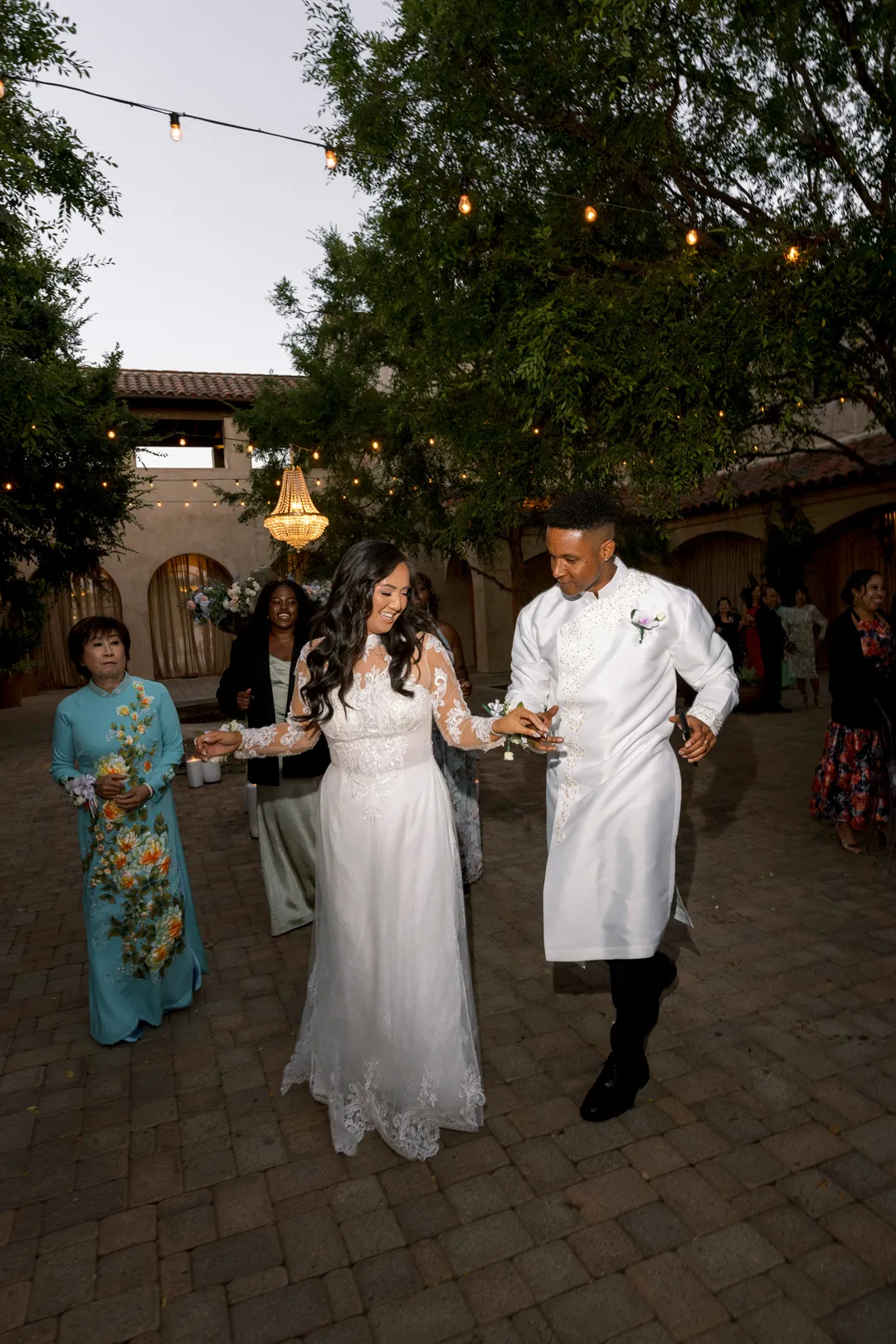 Newlyweds dancing together in the Serra Plaza courtyard at dusk.
