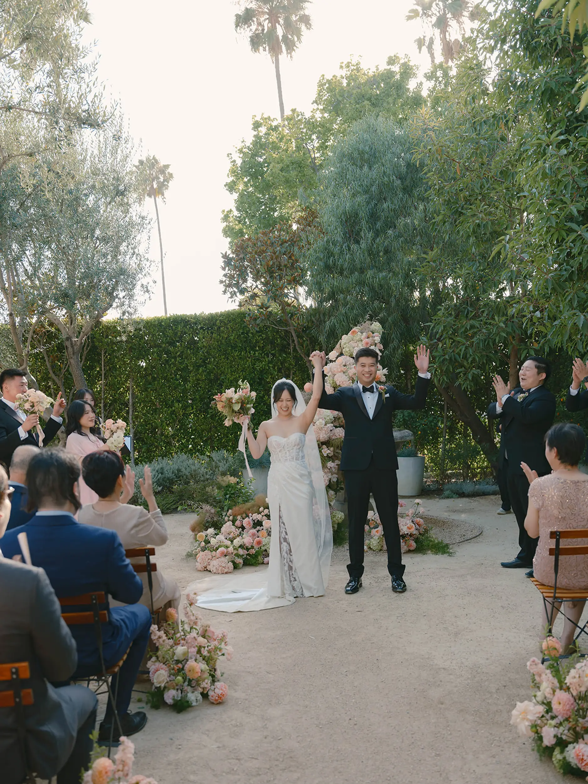 Bride and groom celebrate their marriage at they make their ceremony exit outside in Grand Gimeno's Olive Grove.