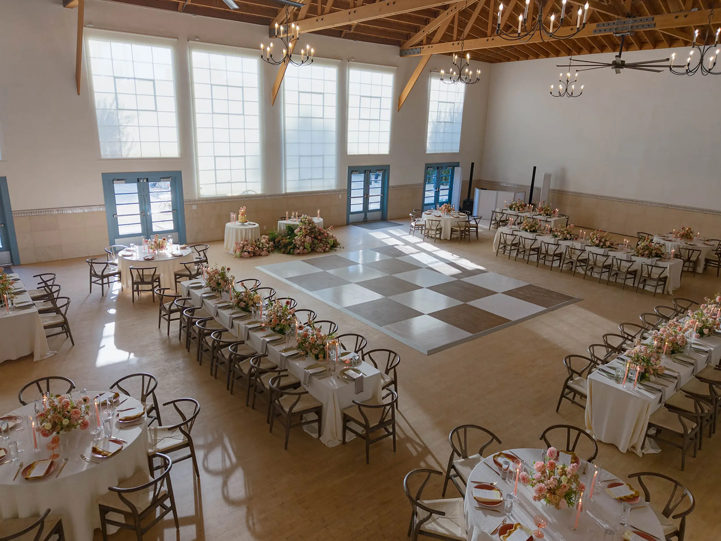 A birds-eye view of the indoor wedding reception at Grand Gimeno where tables frame in a white and brown checkered dance floor.