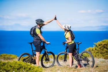 Couples with bikes with a beautiful view towards the ocean.
