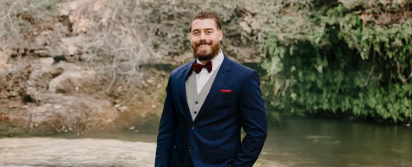 Matthew smiling proudly in front of a camera