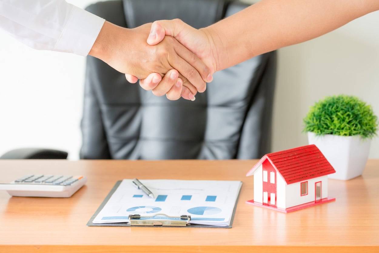 Hands of agent and client shaking hands after signed contract buy new apartment.