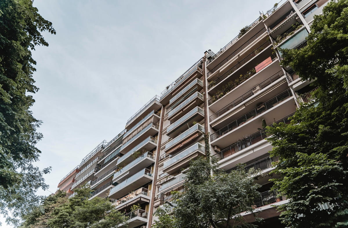 A multi-story apartment building showcasing a variety of balconies throughout its structure. 