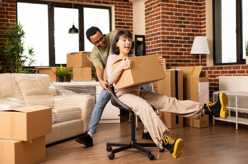 Smiling partners make memories on moving day riding through living room