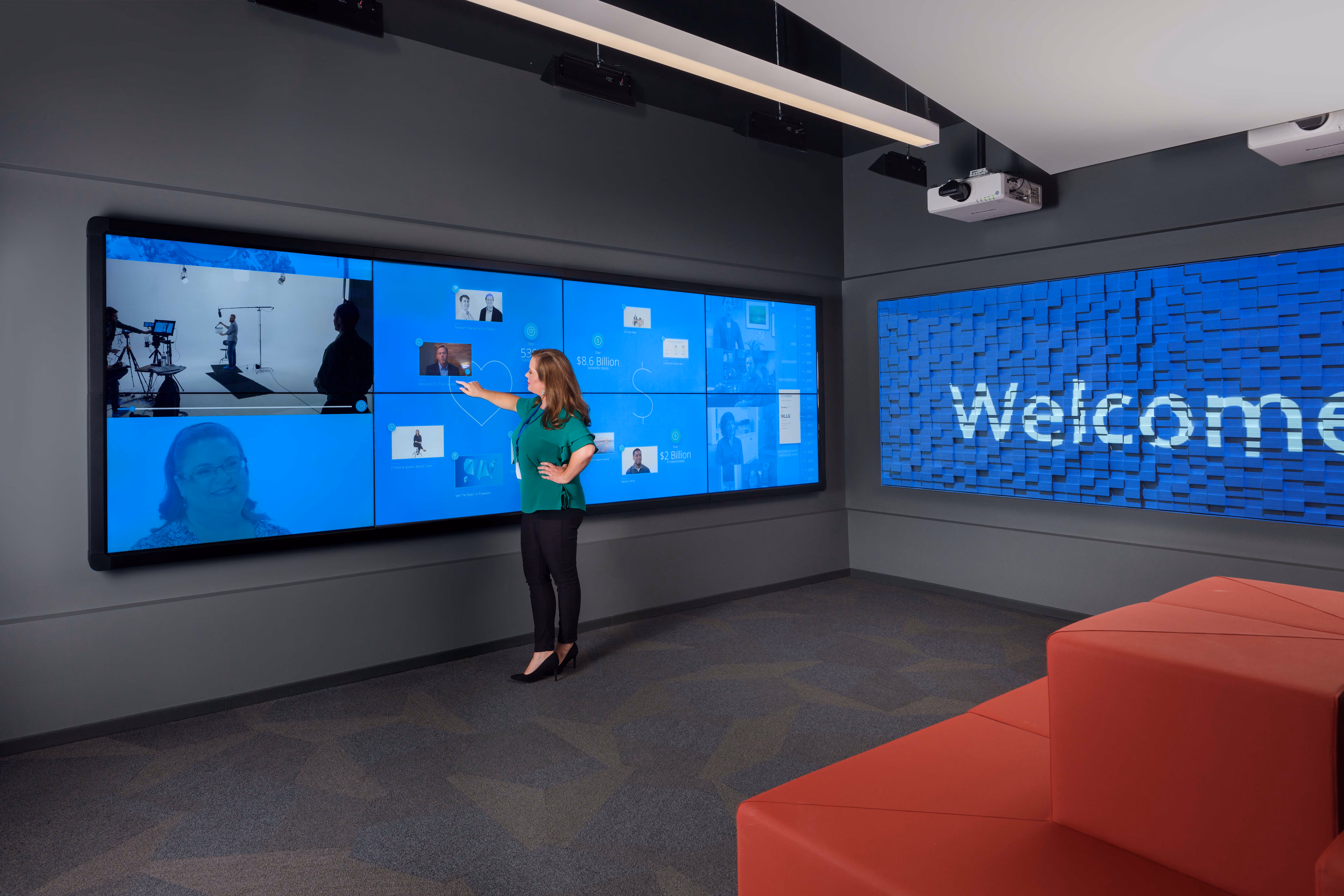 Photo of lady interacting with an interactive video wall.