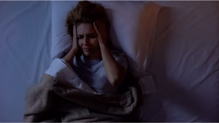 Women with migraine on a bed