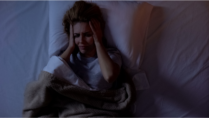 Women with migraine on a bed