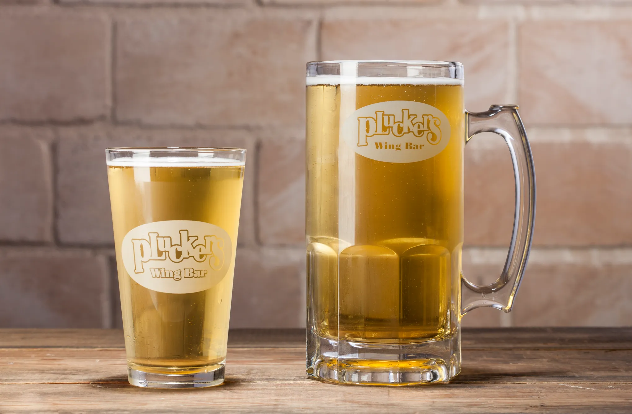 Pluckers draft beer in a pint glass and Mother Plucker mug