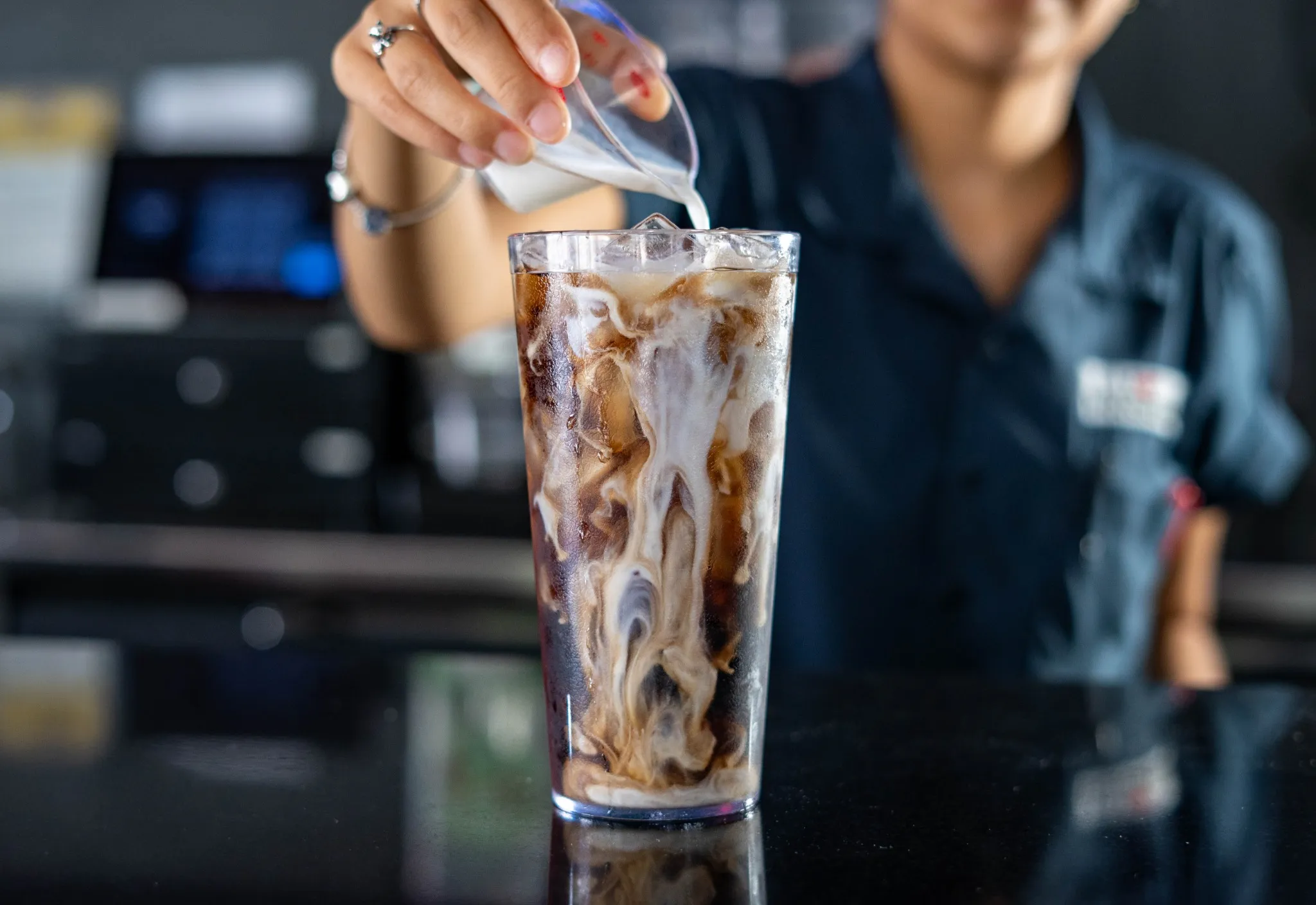 Cream being poured into a Pluckers DIY soda