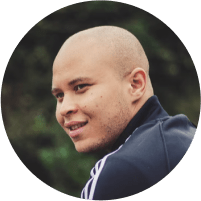 A white man in his late 20's with a shaved head.